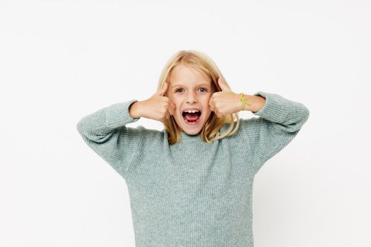 emotional girl in a sweater, grimaces on a light background. High quality photo