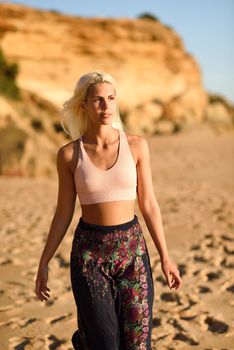 Woman enjoying the sunset on a beautiful beach in Cadiz, Andalusia, Spain. Young female walking on the sand with golden light.