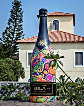 Nasik, India - November 18th, 2017: Big wine bottle sculpture made of cement displayed in the premises of Sula winery in Nasik, Maharashtra, India.