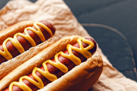 Barbecue Grilled Hot Dogs with  yellow American mustard, On a dark wooden background