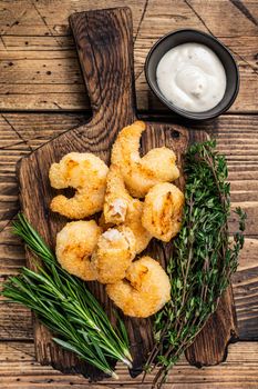 Fried Crispy Shrimps Prawns on a wooden board with sauce. wooden background. Top view.