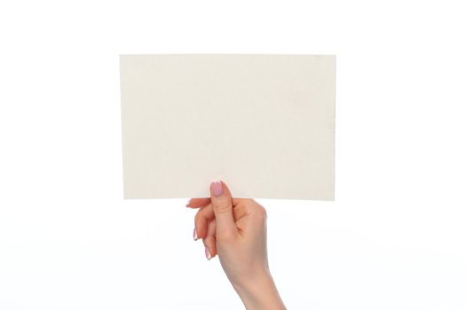 Female hand holding blank white sheet of paper isolated on white background