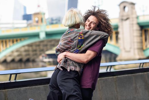 Happy couple hugging near the Southwark bridge over River Thames, London. UK