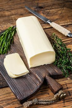 Butter sliced Spread block on a wooden board with herbs. wooden background. Top view.