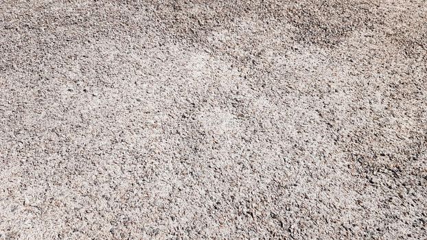 Crushed gravel texture background in natural light. Fine gray gravel for background or texture. Natural building material for road construction or landscape architecture. Construction industry.