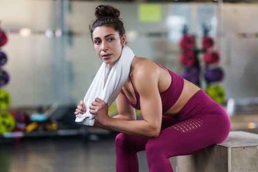 Woman Resting After Exercises In Gym with a white Towel