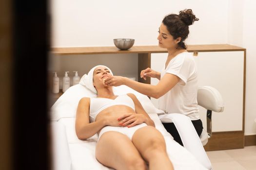 Aesthetics cleaning the skin to the face of a middle-aged woman in modern wellness center.. Beauty and Aesthetic concepts.