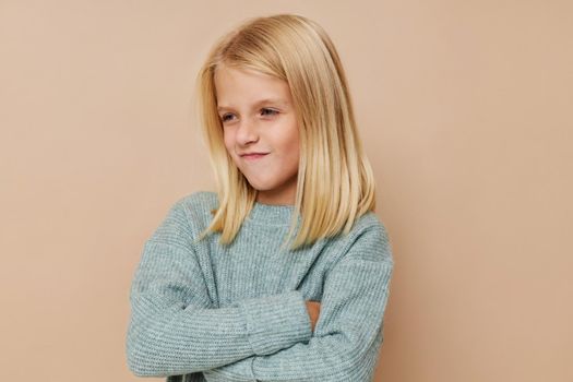 Beautiful little girl in a sweater, grimaces kids lifestyle concept. High quality photo