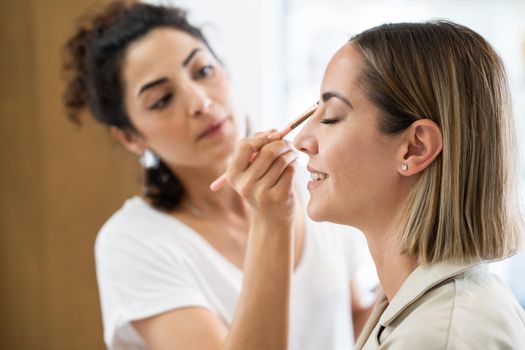 Arab makeup artist making up a woman in a beauty center. Beauty and Aesthetic concepts.