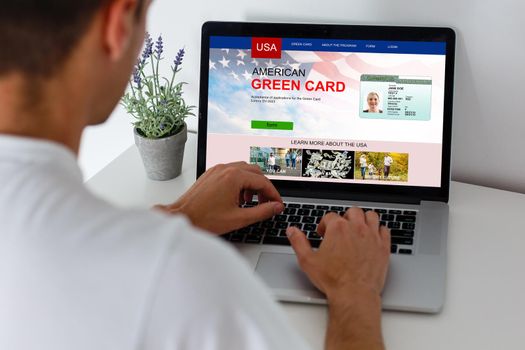 man with laptop with United States Permanent Resident Card website.