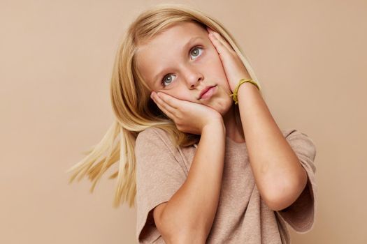 happy child in a beige t-shirt on a beige background. High quality photo
