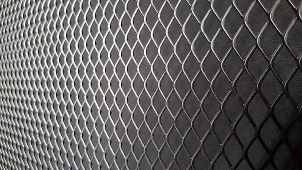 Metal mesh seamless pattern. Black metal mesh texture on a black background. Bulletin board for text and message design. Rhombus shape.