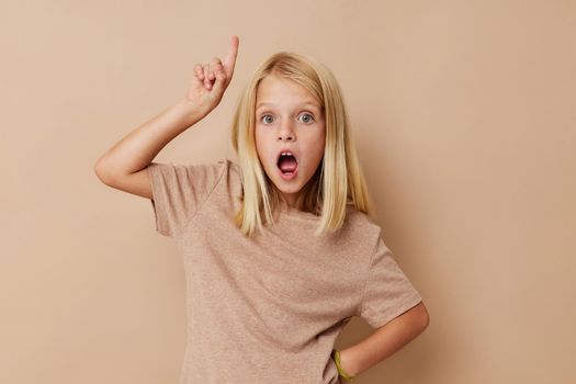 Positive little girl in a beige t-shirt lifestyle concept. High quality photo