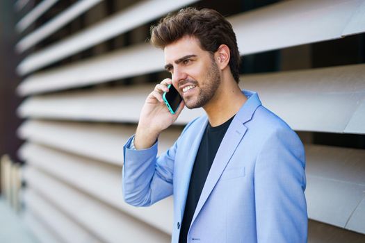 Man talking to his smartphone with a happy expression outdoors