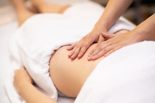 Woman receiving a belly massage in a physiotherapy center. Female patient is receiving treatment by professional osteopathy therapist.