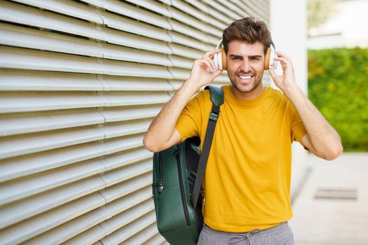 Portrait of young man with headphones in urban background