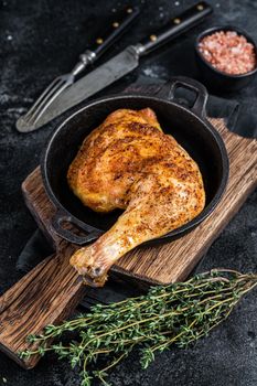 Fried bbq chicken leg in a pan. Black background. Top view.