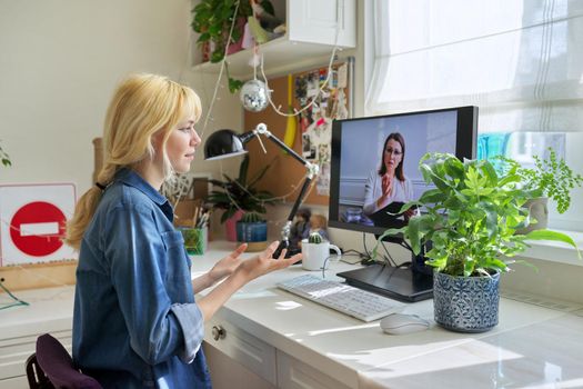 Teen girl talking online with psychologist, social worker. Teenager sitting at home using video call on computer for virtual meeting with counselor. Technology, adolescence, mental health