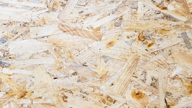 OSB sheet is made of pressed brown wood shavings. Attic wall surfaces. Material for building a house
