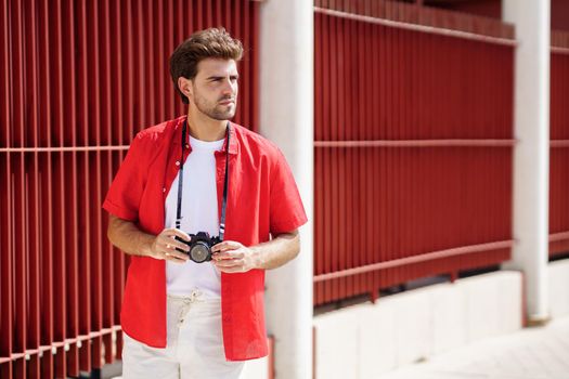 Millennial man traveling with a SLR camera outdoors