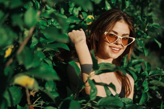 cheerful fashionable woman in sunglasses and green leaves summer luxury. High quality photo
