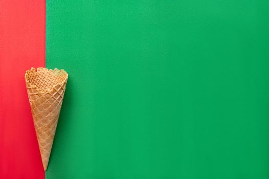 Top view at the empty waffle cone on red and green background, special concept, enough place for text