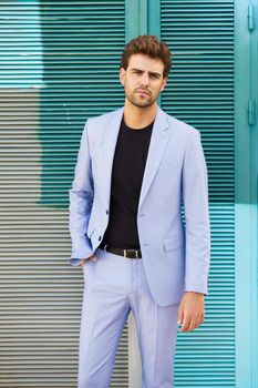 Attractive young man wearing suit standing outdoors.