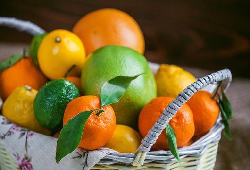 citrus fruits in a wicker basket on a wooden background