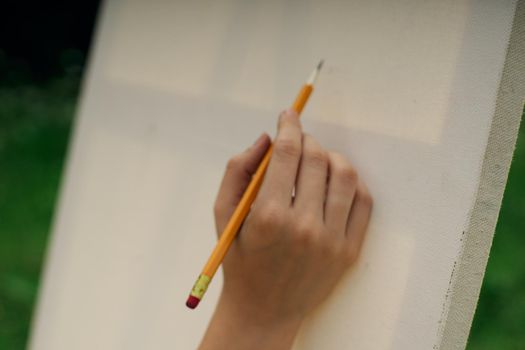 female hand with pencil easel drawing close up. High quality photo