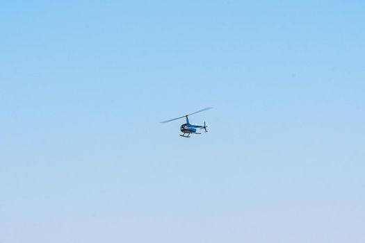 Helicopter flying in the blue sky during a sunny day