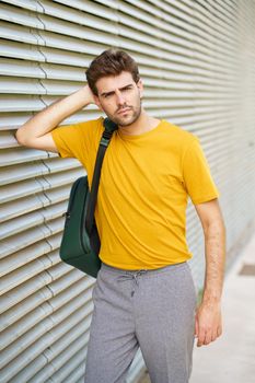 Portrait of young man with modern haircut in urban background