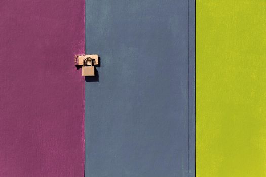 a door lock on a colorful wall, pink, gray, yellow.