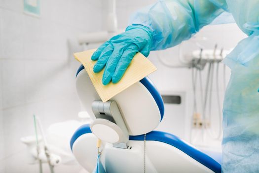 A nurse disinfects work surfaces in the dentist's office..