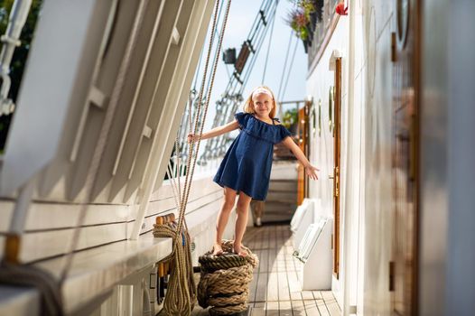 A little girl on the deck of a large sailboat in the city of Klaipeda.Lithuania.