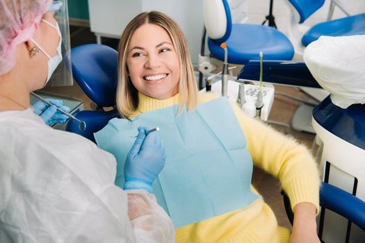 The girl smiles at the dentist and looks at her.