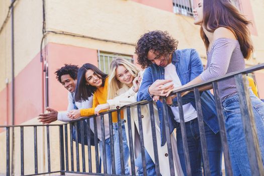 Multiracial group of young people talking together in the street. Students socializing.