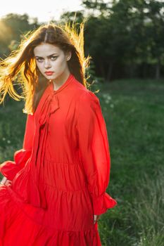 attractive woman in red dress outdoors in freedom field. High quality photo
