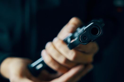 Muzzle of gun close-up. Man reloading pistol. Weapon ammunition. Firearms in hand on dark background. Defense or attack.