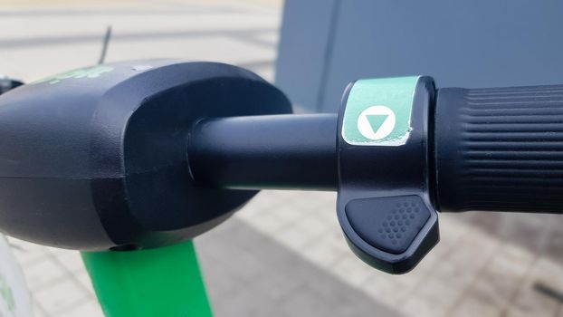 Close up of the steering wheel of an electric scooter. City electric scooter rental outside. Riding safety problem. Ecological transport concept