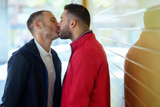 Gay couple kissing on the street. Homosexual relationship concept.