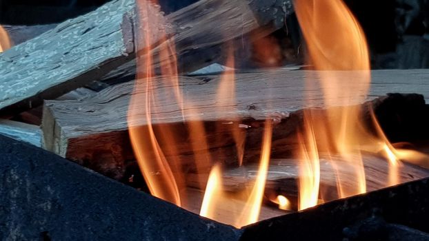 Flame dance, barbecue on an open fire. fire in the grill with burning wood. Prepare charcoal before grilling meat or fish outdoors. Flame in the fireplace. BBQ preparation.