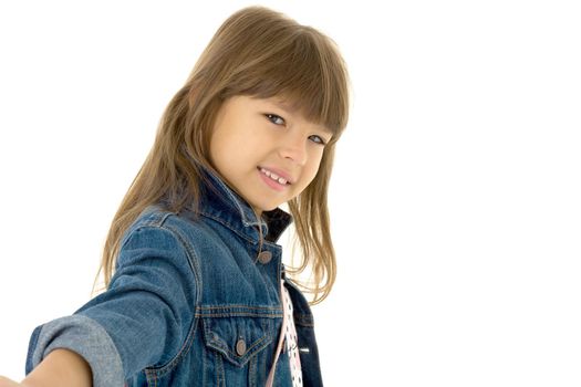 Portrait of happy girl in stylish outfit. Beautiful smiling brown eyed preteen girl wearing denim jacket posing against white background with crossbody shoulder bag