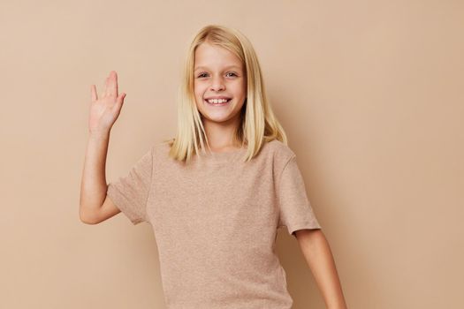 Portrait of a smiling little cutie in a beige t-shirt isolated background. High quality photo