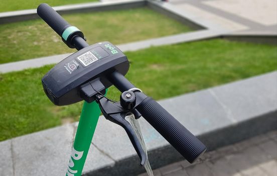 Close up of the steering wheel of an electric scooter. City electric scooter of the Bolt company for rent standing outside. Ecological transport concept. Ukraine, Kiev - October 17, 2020