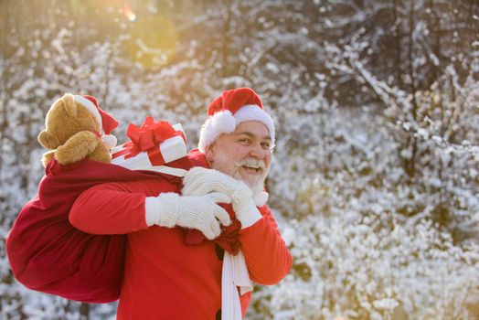 Santa grandfather deliver gifts. Santa Claus in snowy winter mountain. New Year and xmas is coming