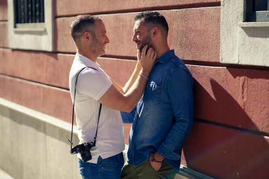 Gay couple tourists in a romantic moment on the street. Homosexual relationship concept.