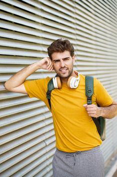 Portrait of young man with headphones in urban background