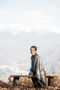 Young woman sitting on bench on viewing platform outdoor.