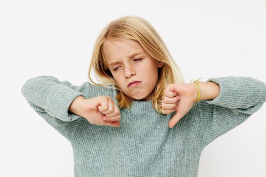 Positive little girl with blond hair on a light background. High quality photo