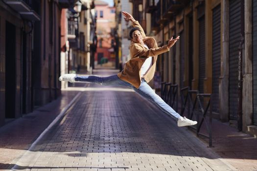 Young black man doing an acrobatic jump in the middle of the street. Cuban guy.